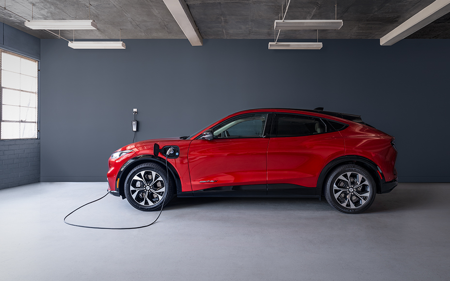 Red Mach E plugged into a charger